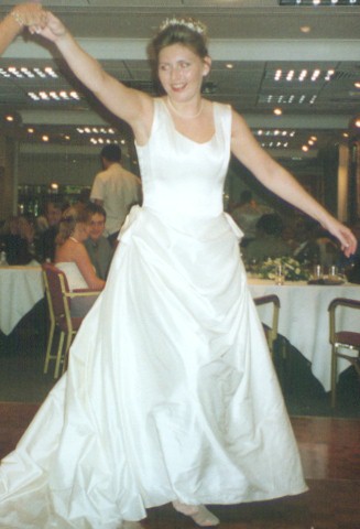 smiling bride dancing in white wedding dress